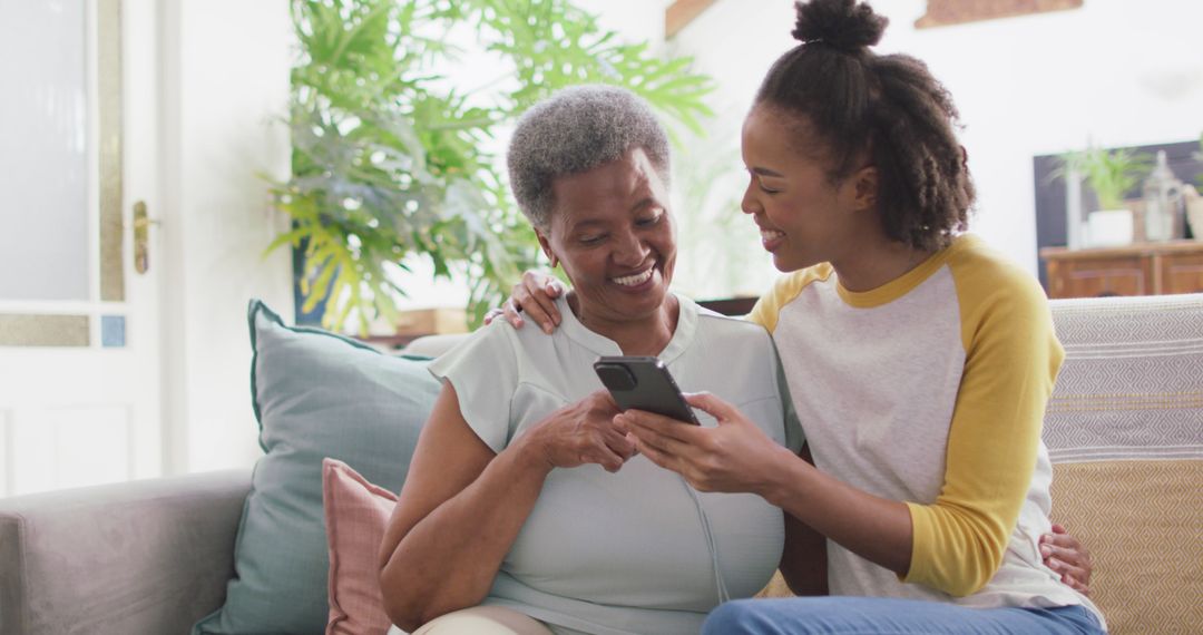 Elderly Woman and Young Woman Smiling While Using Smartphone Together - Free Images, Stock Photos and Pictures on Pikwizard.com