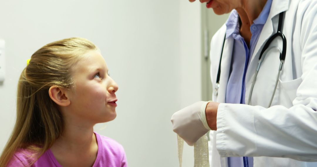 Doctor Wrapping Bandage on Happy Young Girl's Arm During Medical Exam - Free Images, Stock Photos and Pictures on Pikwizard.com