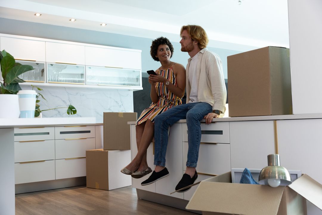 Couple Relaxing in New Kitchen Unpacking Moving Boxes
