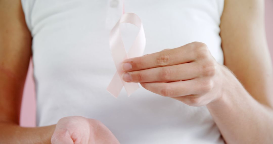 Close-Up of Woman Holding Pink Ribbon for Breast Cancer Awareness - Free Images, Stock Photos and Pictures on Pikwizard.com