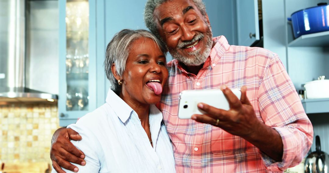 Happy Senior Couple Taking a Selfie in Kitchen - Free Images, Stock Photos and Pictures on Pikwizard.com