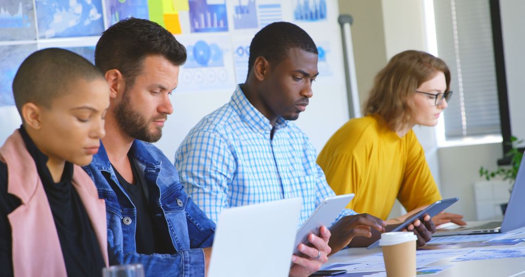 Diverse Business Team Collaborating on Digital Devices in Office