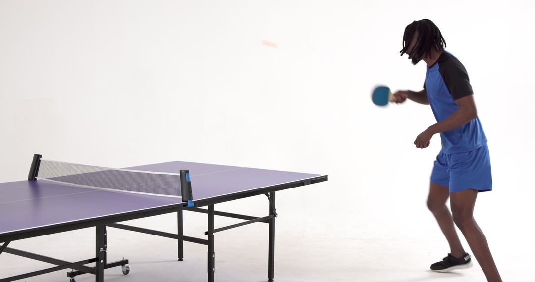 Athletic Man Playing Table Tennis in Studio Environment