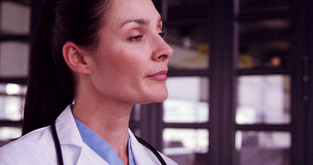 Focused Female Doctor in Medical Uniform Looking Away Thoughtfully - Free Images, Stock Photos and Pictures on Pikwizard.com