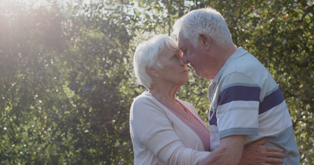 Elderly Couple Showing Affection Outdoors in Sunlight - Free Images, Stock Photos and Pictures on Pikwizard.com