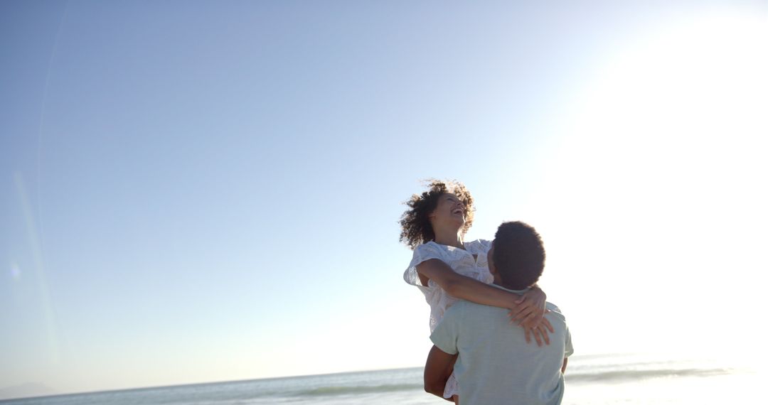 Joyful Couple Embracing on Sunny Beach with Clear Skies