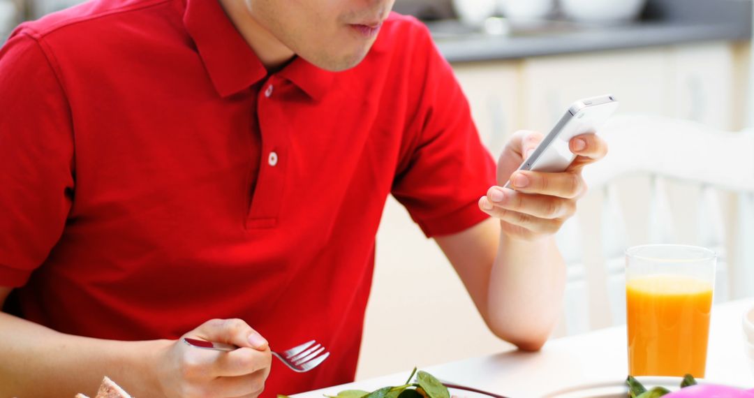 Man Eating Salad While Using Smartphone at Breakfast Table - Free Images, Stock Photos and Pictures on Pikwizard.com