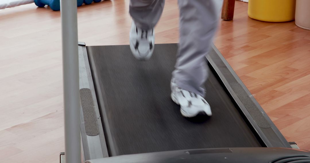 Person Running on Treadmill in Gym with Wood Flooring - Free Images, Stock Photos and Pictures on Pikwizard.com