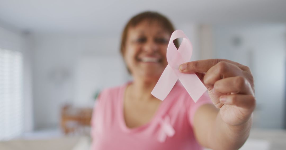 Smiling Woman Holding Pink Ribbon Promoting Breast Cancer Awareness - Free Images, Stock Photos and Pictures on Pikwizard.com