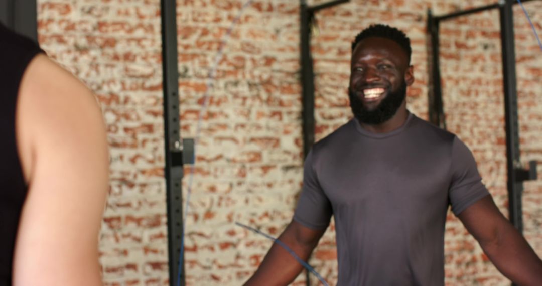 Smiling Fitness Instructor Guiding Jumprope Workout in Gym