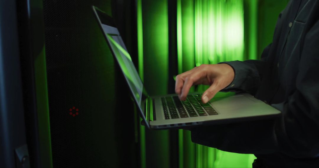 Cybersecurity Professional Working on Laptop in High-Tech Server Room
