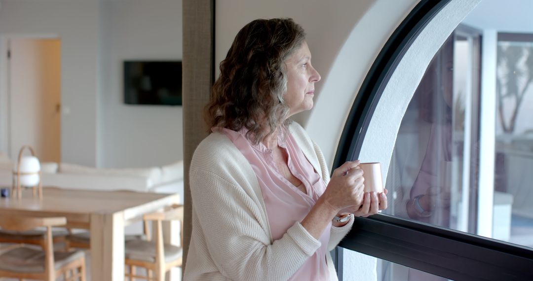 Senior Woman Enjoying Quiet Moment by Arched Window at Home