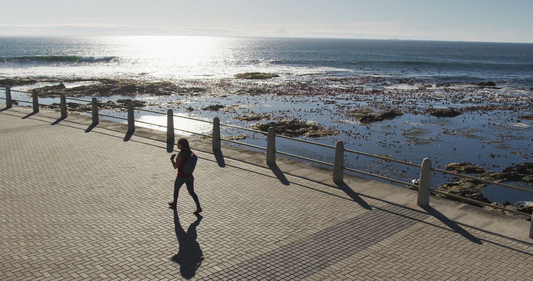 Woman Jogging Along Seaside Promenade at Sunset - Free Images, Stock Photos and Pictures on Pikwizard.com