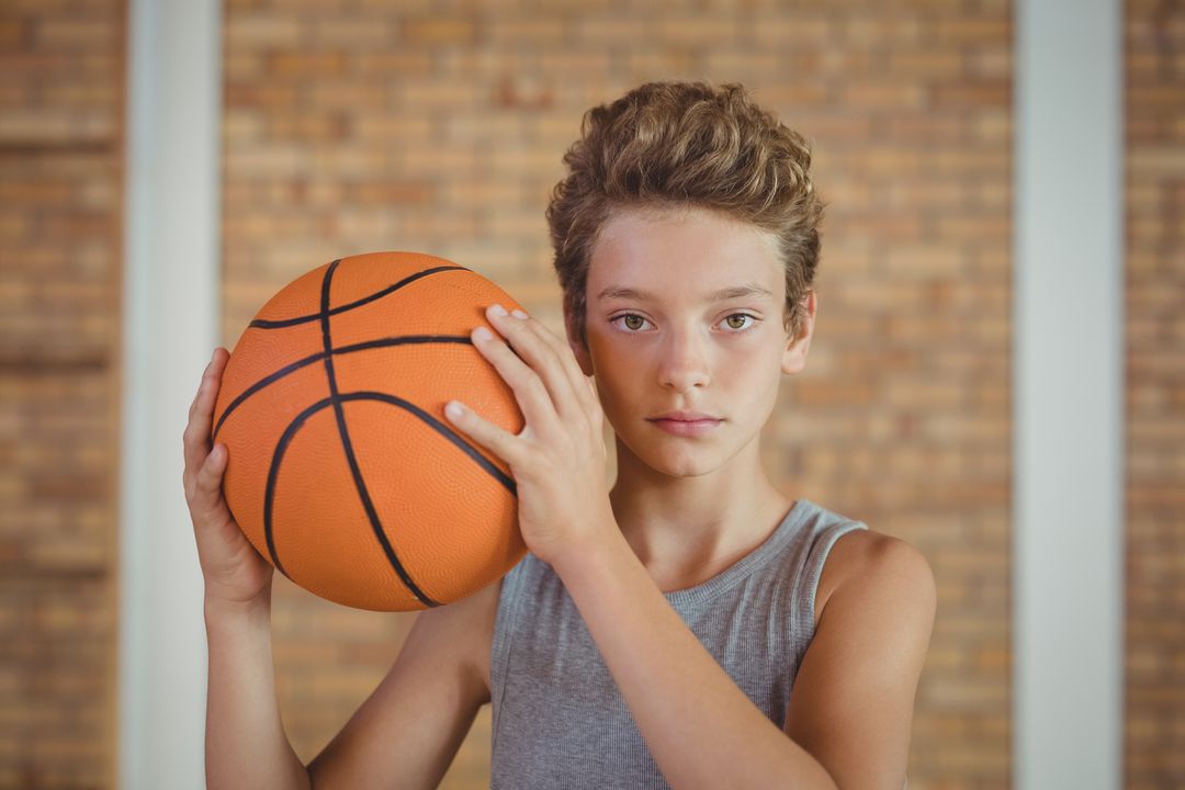 Determined boy holding a basketball - Free Images, Stock Photos and Pictures on Pikwizard.com