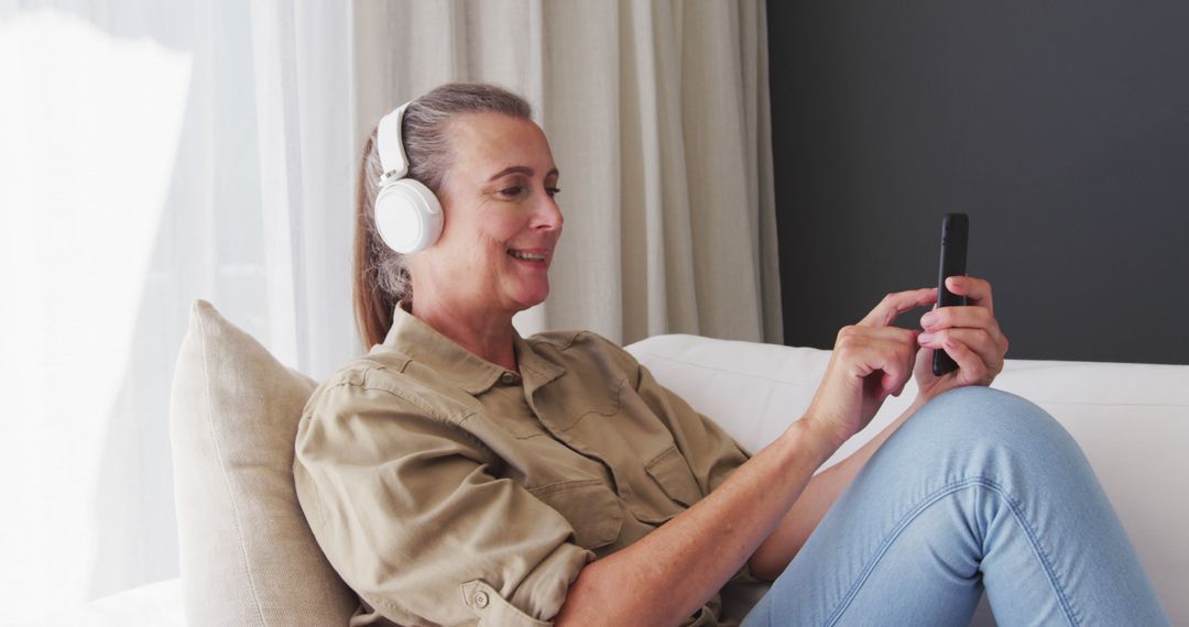 Relaxed Older Woman Enjoying Music with Headphones at Home - Free Images, Stock Photos and Pictures on Pikwizard.com