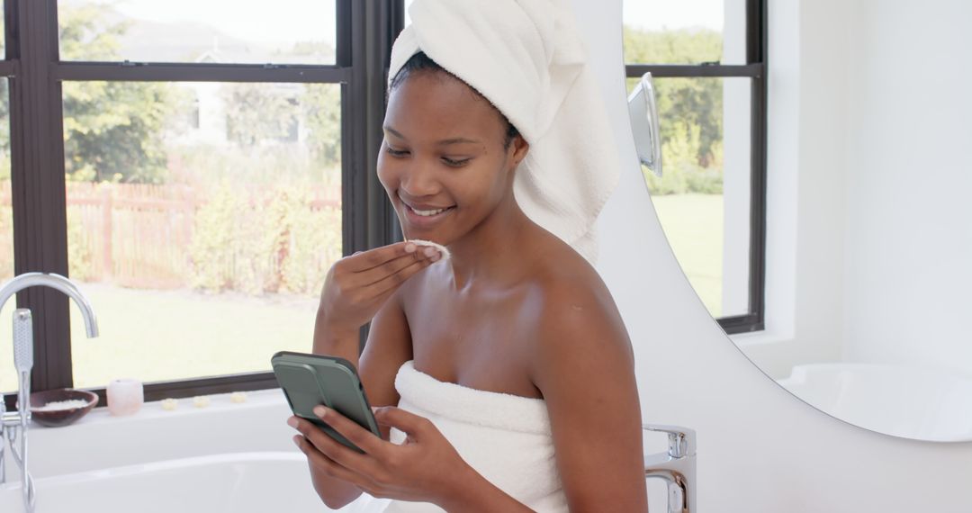 Smiling Woman in Towels Using Smartphone in Bright Bathroom - Free Images, Stock Photos and Pictures on Pikwizard.com