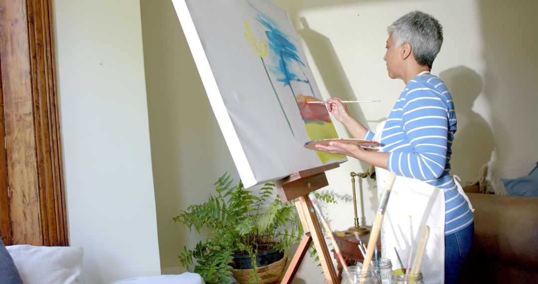 Elderly Woman Painting on Canvas at Home Showing Artistic Expression and Creativity