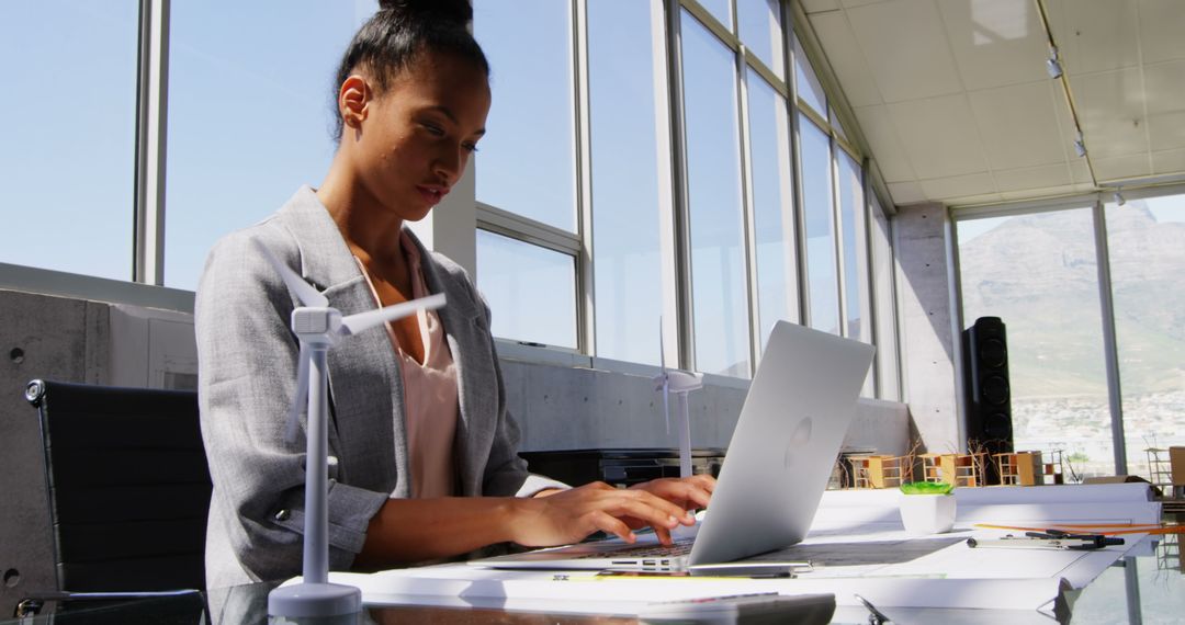 Focused Businesswoman in Modern Office with Windmill Models