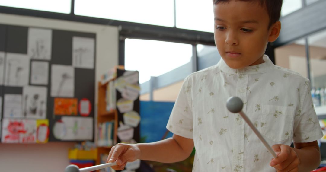 Asian Boy Playing Xylophone in Occupied Classroom