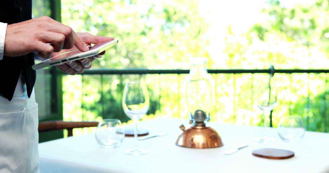 Waiter Using Tablet in Outdoor Restaurant - Free Images, Stock Photos and Pictures on Pikwizard.com