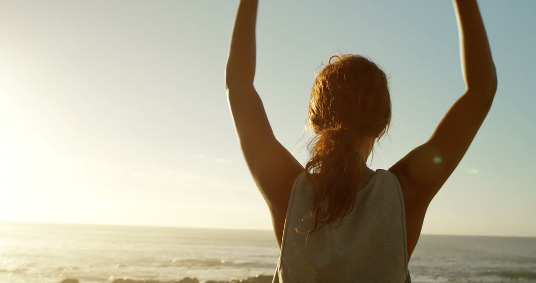 Woman Celebrating Beach Sunrise with Hands Raised - Free Images, Stock Photos and Pictures on Pikwizard.com