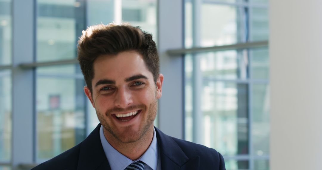 Young Professional Man Smiling in Modern Office Space - Free Images, Stock Photos and Pictures on Pikwizard.com