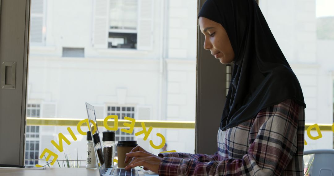 Hijab-Wearing Woman Typing on Laptop at Bright Office Workspace - Free Images, Stock Photos and Pictures on Pikwizard.com