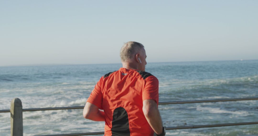 Senior Man Running Along Seaside Promenade in Red Shirt - Free Images, Stock Photos and Pictures on Pikwizard.com