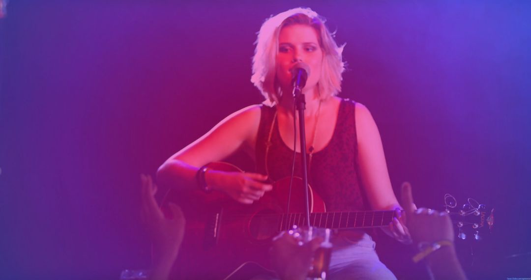 Teen Musician Singing on Stage with Acoustic Guitar and Stage Lights