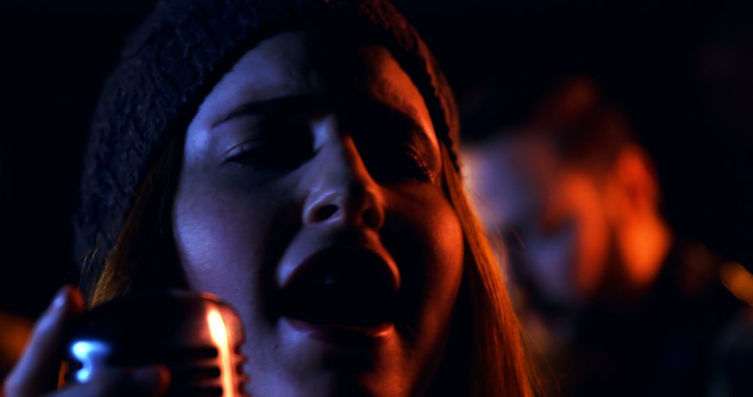 Woman Singing in Dark Moody Lighting with Retro Microphone - Free Images, Stock Photos and Pictures on Pikwizard.com