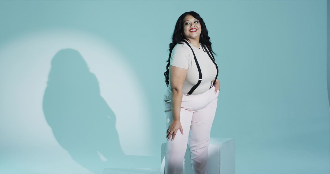 Elegant Woman Posing Confidently in Teal Spotlight Minimalistic Studio