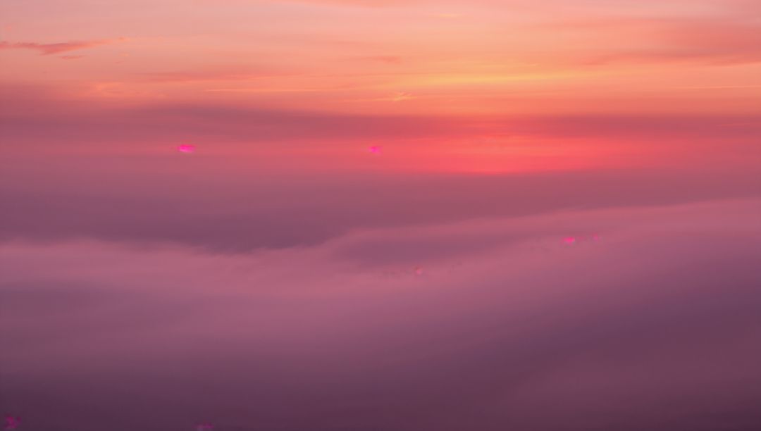 Majestic Sunrise Above Clouds with Ethereal Colors