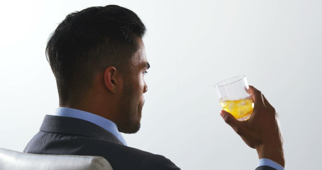 Businessman Relaxing with Whiskey on Ice in Modern Office - Free Images, Stock Photos and Pictures on Pikwizard.com