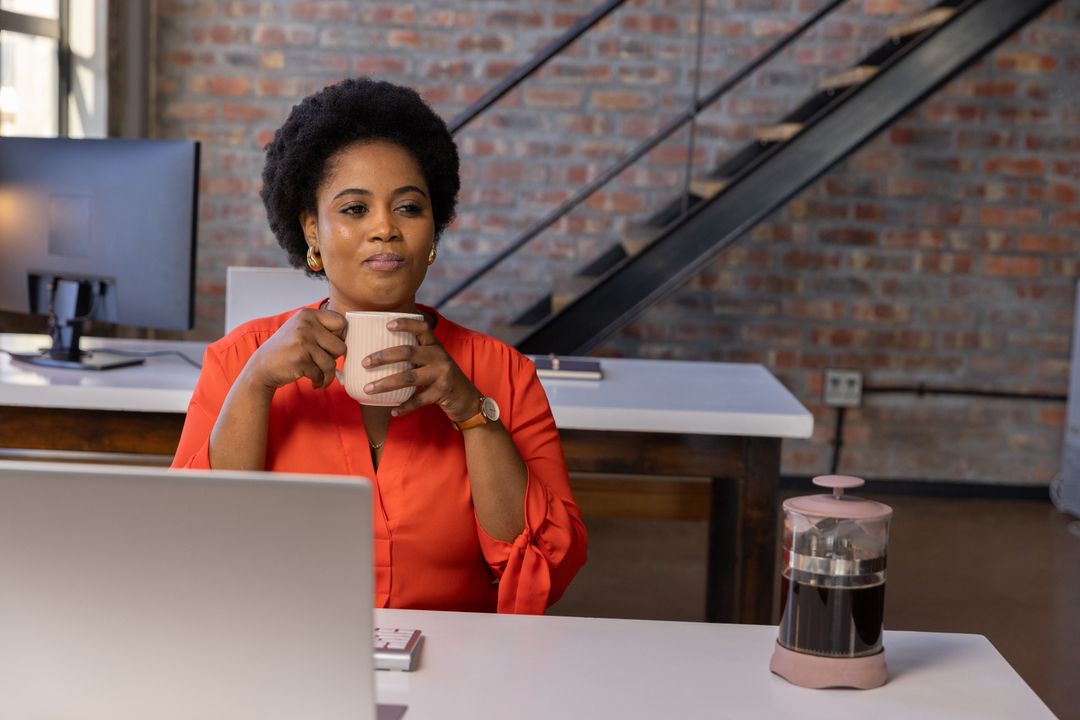 Professional Woman Enjoying Coffee While Focused at Work in Modern Office
