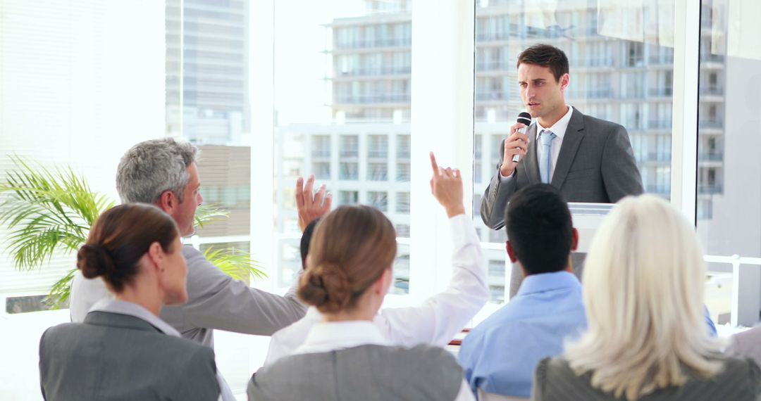 Young Businessman Leading Q&A Session with Engaged Professionals in Modern Office - Free Images, Stock Photos and Pictures on Pikwizard.com