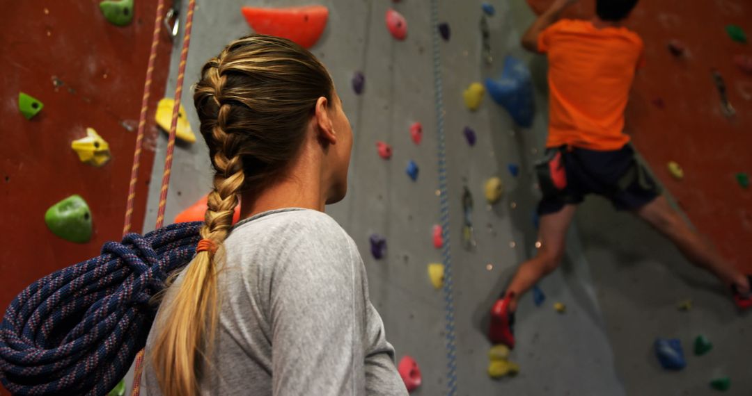 Female Climber Watching Partner Ascend Indoor Climbing Wall for Motivation and Support - Free Images, Stock Photos and Pictures on Pikwizard.com