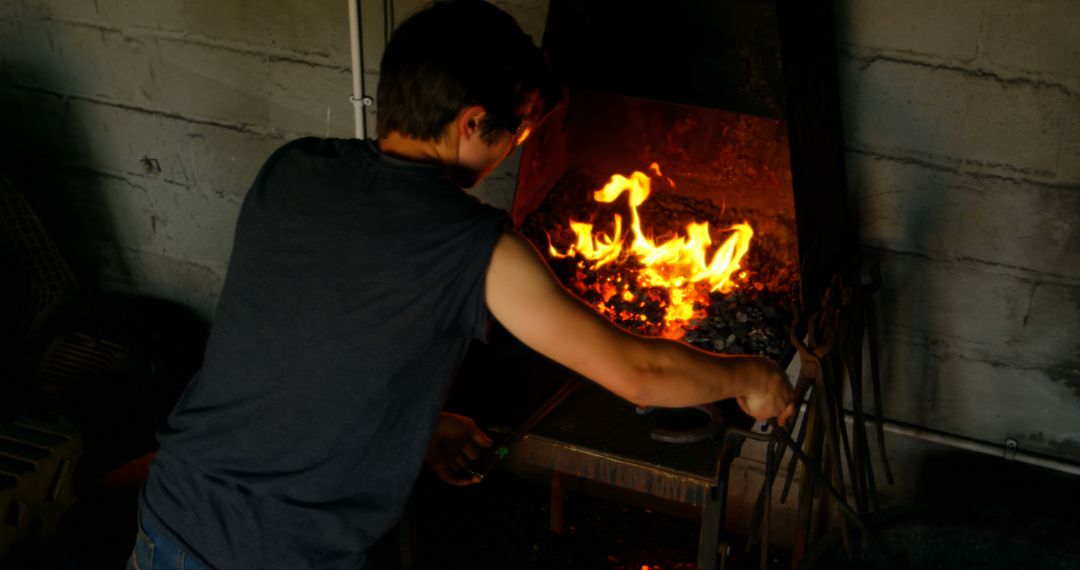 Young Blacksmith Working with Fire in Workshop - Free Images, Stock Photos and Pictures on Pikwizard.com