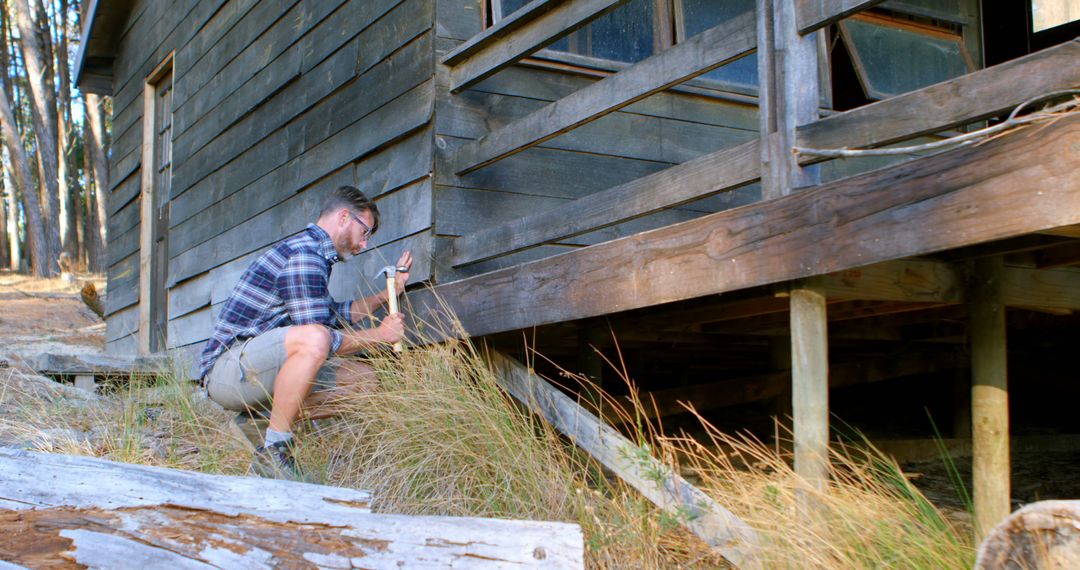 Man Repairing Wooden Cabin's Exterior in Rural Forest - Free Images, Stock Photos and Pictures on Pikwizard.com