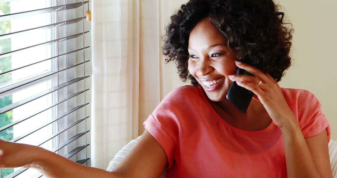 Smiling Woman Talking on Phone near Window with Blinds - Free Images, Stock Photos and Pictures on Pikwizard.com