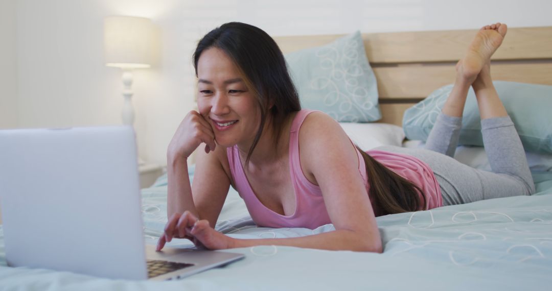 Woman in Casual Clothes Relaxing on Bed Using Laptop - Free Images, Stock Photos and Pictures on Pikwizard.com