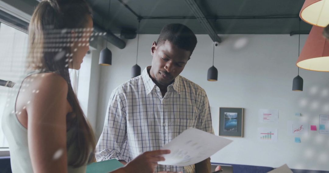 Diverse Team Reviewing Document in Modern Office Environment
