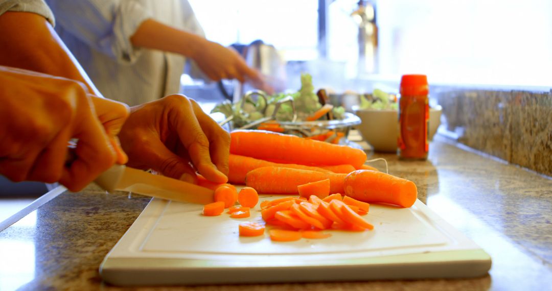 Close-up of Hands Chopping Carrots in Kitchen - Free Images, Stock Photos and Pictures on Pikwizard.com