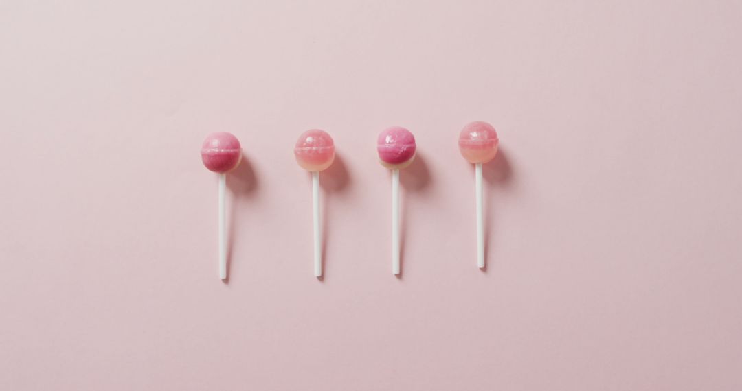 Four Pink Lollipops in Row on Pastel Pink Background, Minimalist Sweet Treat - Free Images, Stock Photos and Pictures on Pikwizard.com