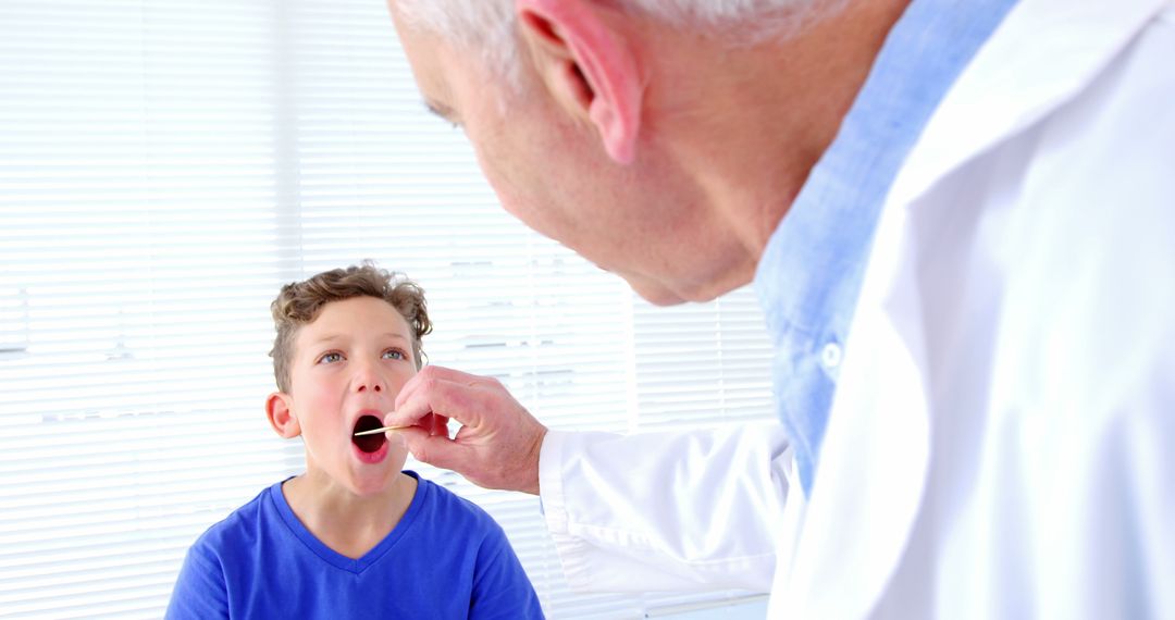 Pediatric Doctor Examining Child's Throat in Bright Office - Free Images, Stock Photos and Pictures on Pikwizard.com