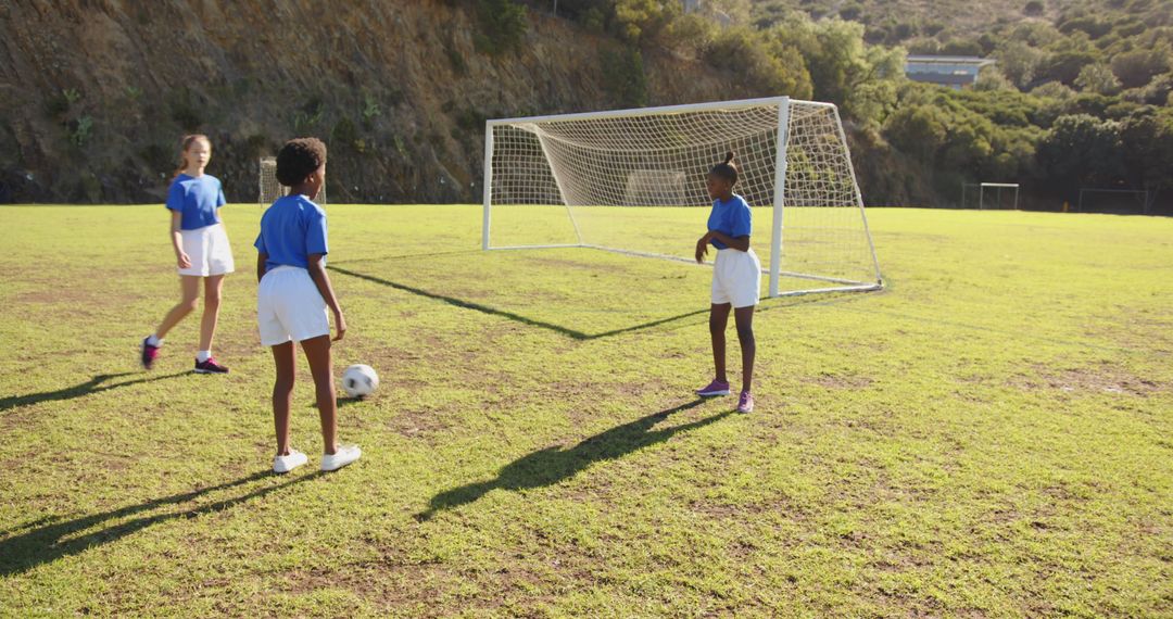 Girls Practicing Soccer on School Field in Bright Sunlight