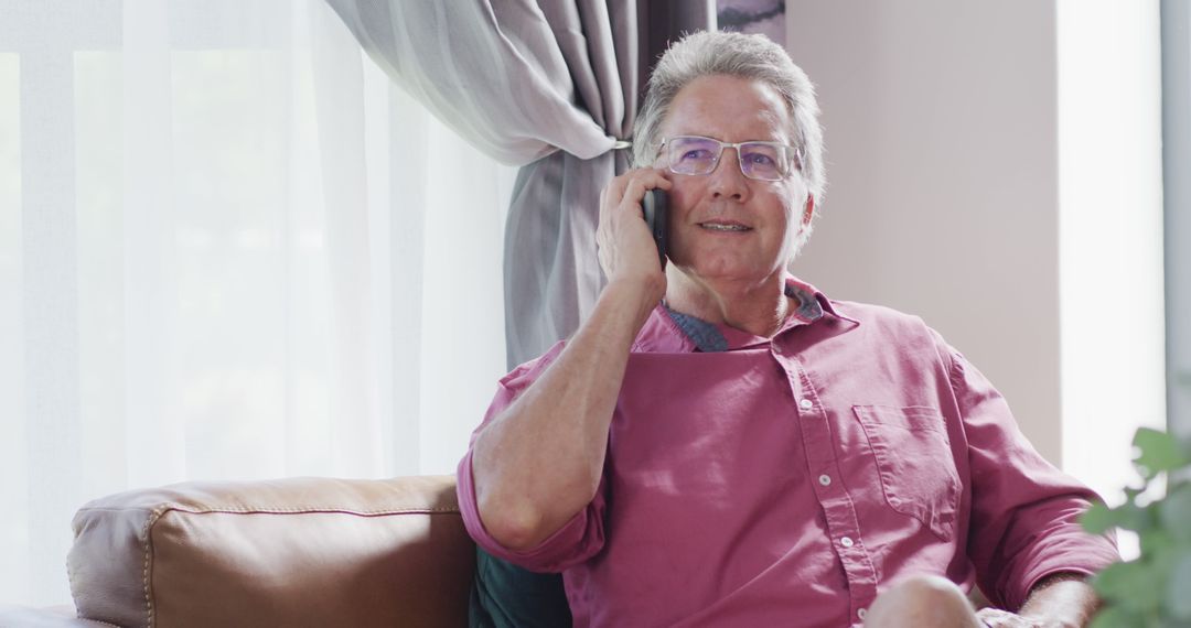 Senior Man in Pink Shirt Talking on Smartphone at Home - Free Images, Stock Photos and Pictures on Pikwizard.com