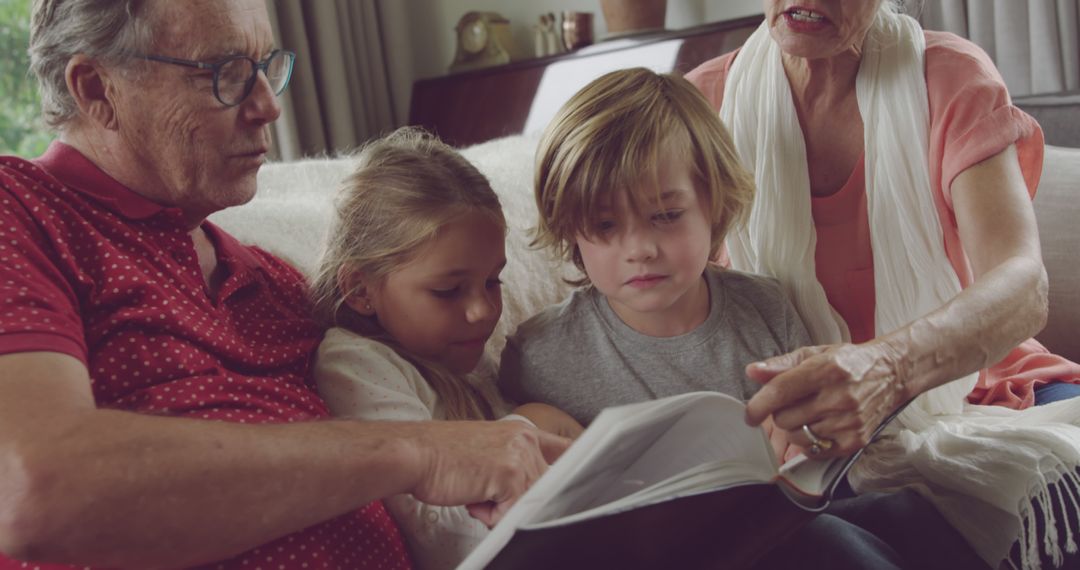 Grandparents Reading Book with Grandchildren on Couch - Free Images, Stock Photos and Pictures on Pikwizard.com