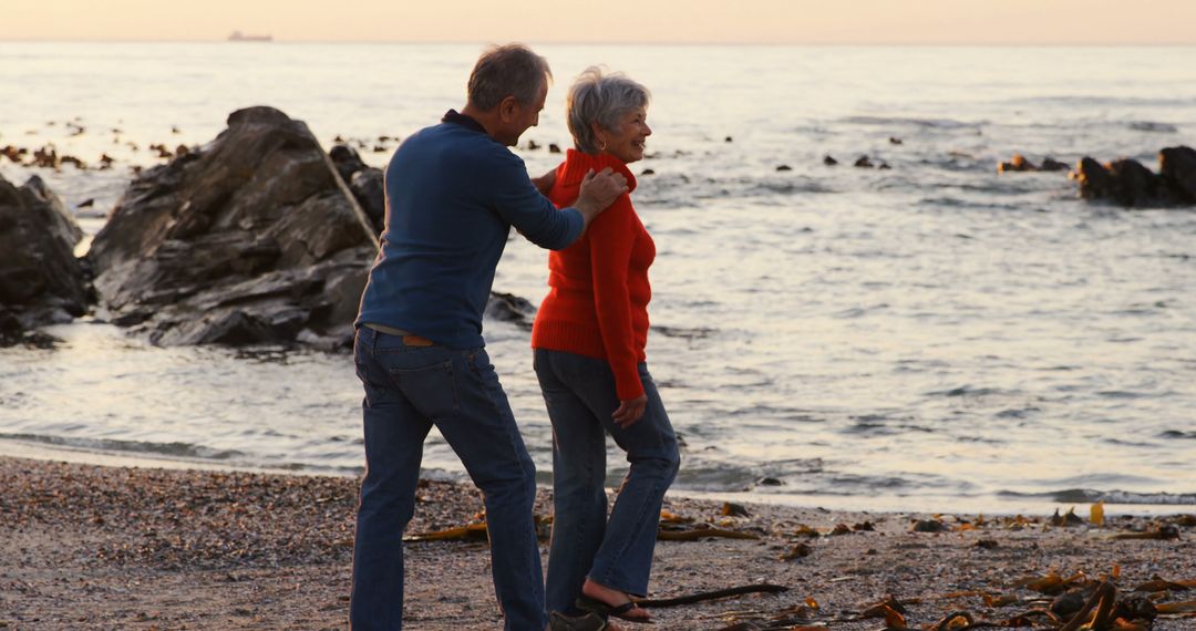 Senior Couple Enjoying Evening Walk on Beach - Free Images, Stock Photos and Pictures on Pikwizard.com