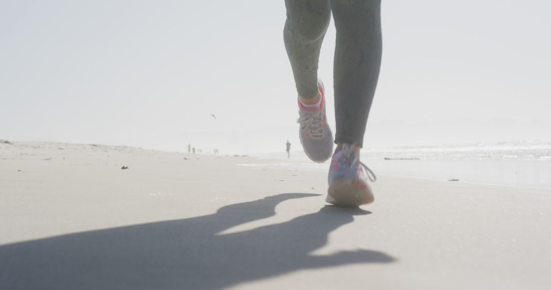 Person Jogging on Sandy Ocean Beach in Morning Light - Free Images, Stock Photos and Pictures on Pikwizard.com