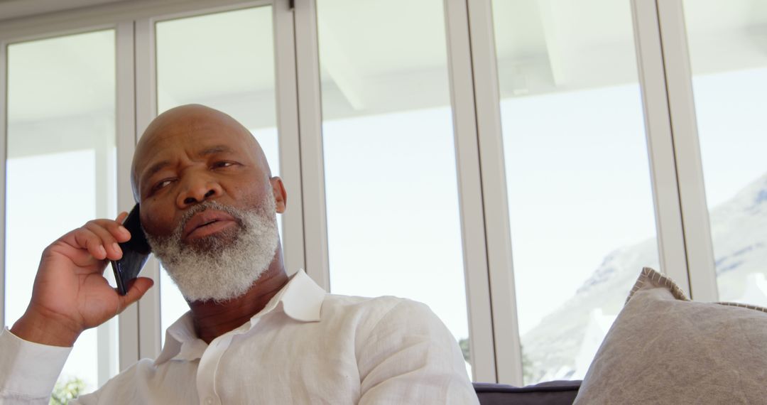 Mature African American Man Talking on Smartphone at Home - Free Images, Stock Photos and Pictures on Pikwizard.com